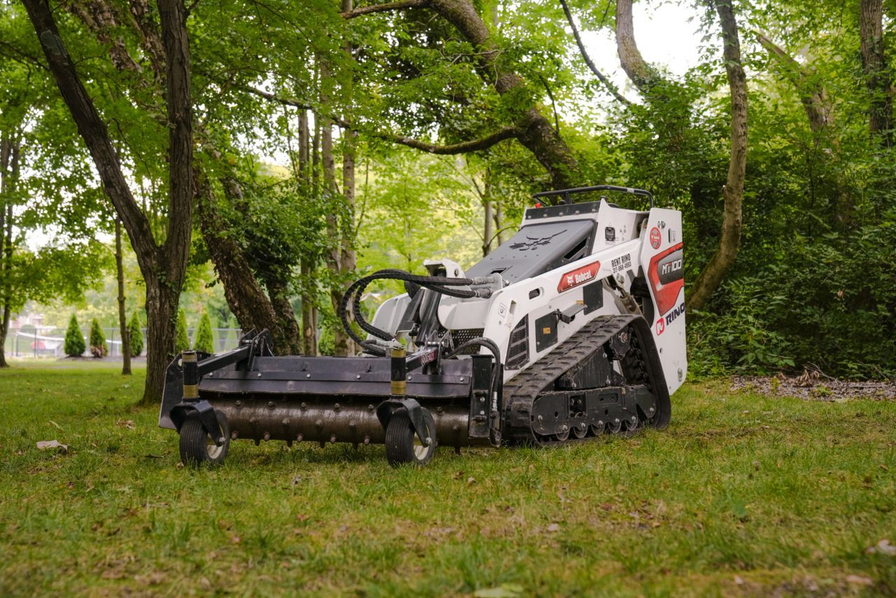 Bobcat MT100 in the forest with a Virnig Power Rake attached and ready to get work done.